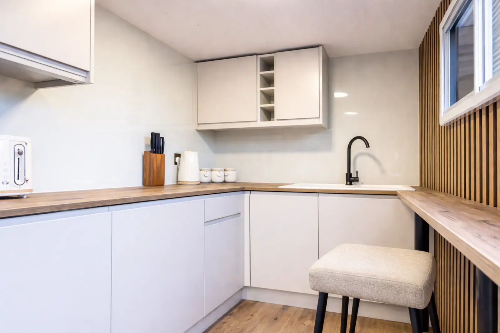 Inside the Kitchen Pod — white cabinetry and timber benchtops